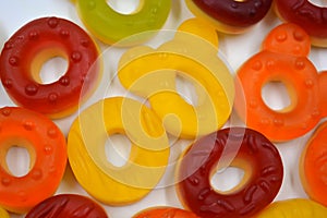 Children\'s sweets in the form of multi-colored donuts, chewable, gelatin sweets are located on a white background.