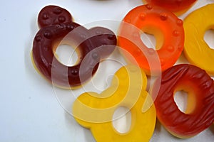 Children\'s sweets in the form of multi-colored donuts, chewable, gelatin sweets are located on a white background.