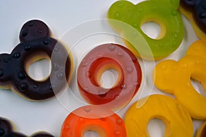 Children\'s sweets in the form of multi-colored donuts, chewable, gelatin sweets are located on a white background.