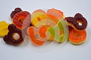 Children\'s sweets in the form of multi-colored donuts, chewable, gelatin sweets are located on a white background.