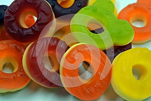 Children\'s sweets in the form of multi-colored donuts, chewable, gelatin sweets are located on a white background.