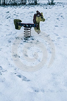 children\'s swing covered with snow on the playground in winter