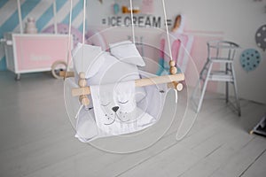 Children`s swing hanging in a beautiful room