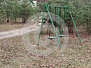 Children`s swing in the recreation area in the forest