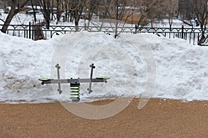 Children`s swing at the snow pile
