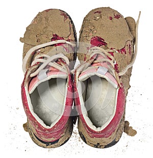 Children`s tiny shoes covered with mud. Dirty leggings for child