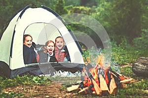 Children`s tourism. Happy kids girls in campaign in tent near f