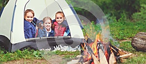 Children`s tourism. Happy kids girls in campaign in tent near f