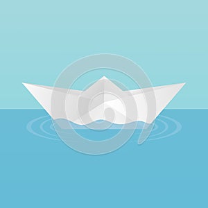 A children`s toy boat made of paper afloat, leaving circles of ripples on the water. On a blue background.