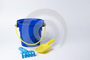 Children`s toy. Bucket with a shovel rake on a white background