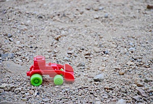 Children`s toy red excavator car on playground, industrail symbols