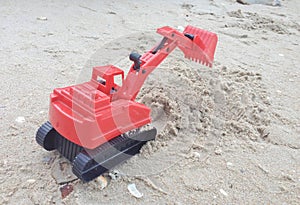 Children`s toy red excavator car on sand,industrail symbols