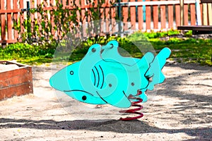 Children`s toy shark, blue color, on the playground for children