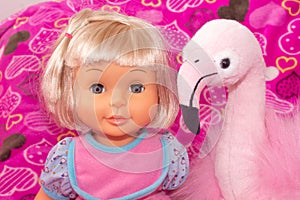 Children`s toys, baby doll and pink flamingo, gifts for children. Holiday with balloons.