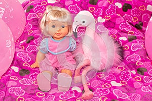Children`s toys, baby doll and pink flamingo, gifts for children. Holiday with balloons.
