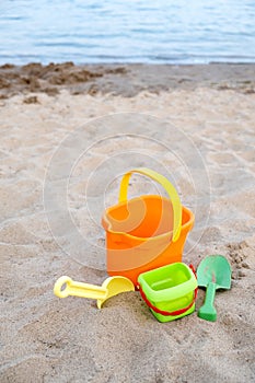 Children`s toys lie on the sand on the beach. Family vacation on the beach.