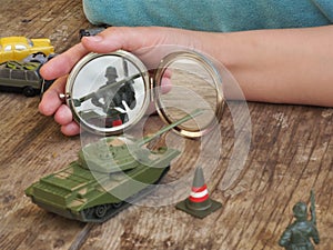 Children`s toys military tank and soldier on a wooden background