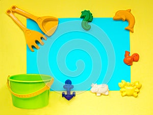 Children`s toys for sand on yellow background.