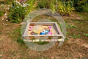 Children`s toys in a sandbox in the village