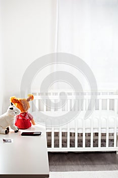 Children`s white room with toys and a cradle. Copy space. Concept of family planning, pregnancy and motherhood