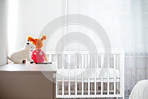 Children`s white room with toys and a cradle. Copy space. Horizontal. Concept of family planning, pregnancy and motherhood