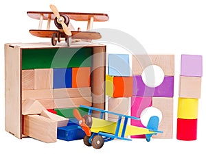 Children`s wooden, geometric shapes, stacked on top of each other, with a model airplane, isolated on white background.