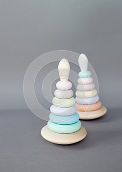 Children's wooden eco-friendly toys pyramids of different sizes of rounded shape on a gray background.