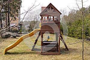 children's wooden playhouse with slide in the yard of the house