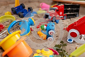 Children's wooden sandbox with various toys for the game.
