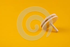 Children`s wooden toy spinning top close up with copy space. Concept of educational games