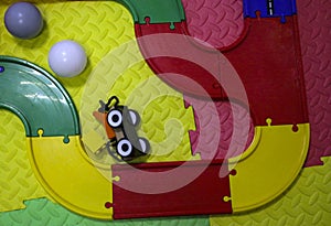 Children`s wooden train with cars, railway and wooden trees on artificial plastic green grass. Early childhood education,