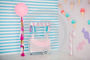 Children`s zone with sweets: lollipops, ice cream, macarons, balloon and candy bar. Children room with blue stripe
