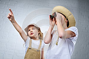 children in safari costumes and hats pointing and looking