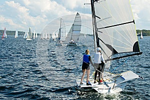 Children Sailing small sailboat stern view on an inland waterw