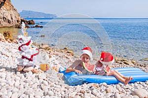 Children in Santa hats on the beach