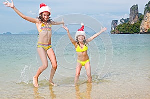 Children in santa hats having fun on beach