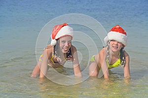 Children in santa hats having fun on beach