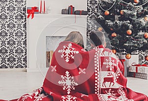 Children in santa hats near christmas tree, wait for holidays