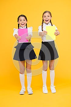 Children with school diaries for notes. Cute schoolgirls holding lesson books. School children learn reading books. Back