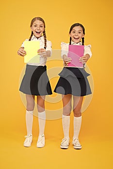Children with school diaries for notes. Cute schoolgirls holding lesson books. School children learn reading books. Back