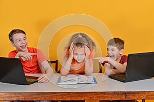Children are schooled at home, two boys are sitting at a laptop, a girl is reading books photo