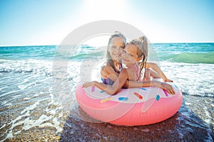 Children at sea play merrily. Two sisters run, jump on the beach in summer.