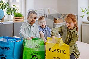 Children separating rubish in to three bins.