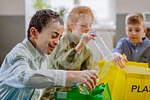 Children separating rubish in to three bins.