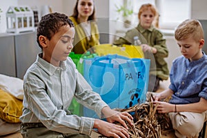 Children separating rubish in to three bins. photo