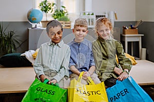 Children separating rubish in to three bins.