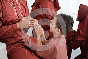 Children shake hands to apologize while celebrating Lebaran