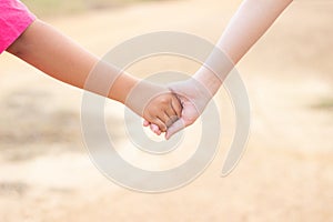 Children shaking hands with blur background,friendship,Girl hold one& x27;s hands walking in road blur background