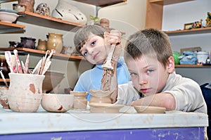 Children shaping clay in pottery studio