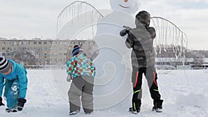 A children is shaping a snowman in heavy snow